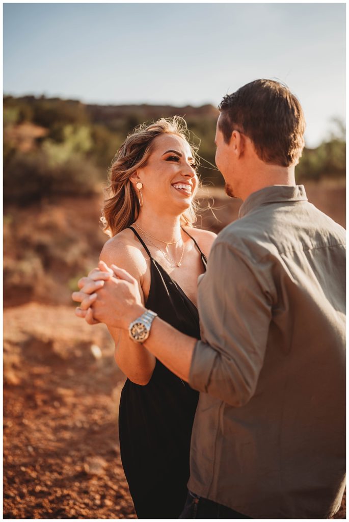couple holds hands while facing each other for Palo Duro Canyon Couple Shoot