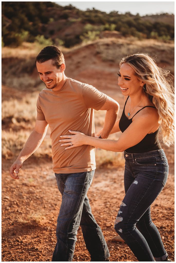 couple laughs while walking by Amarillo Portrait Photographer