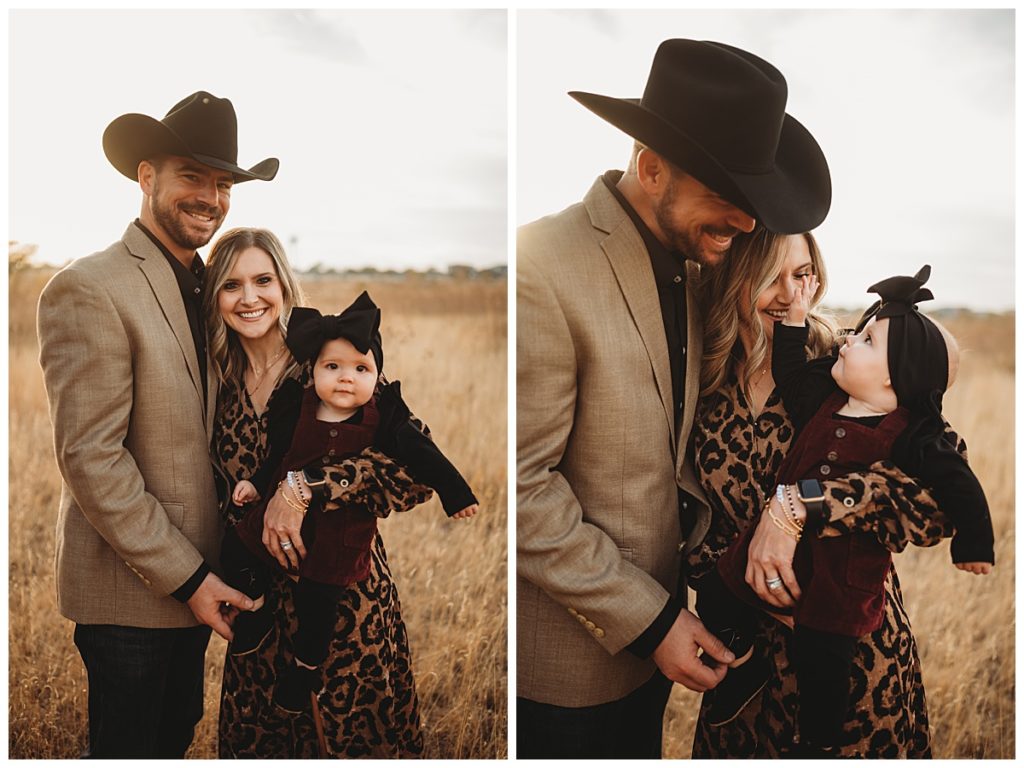 parents and baby stand together in grassy field preparing for family photos