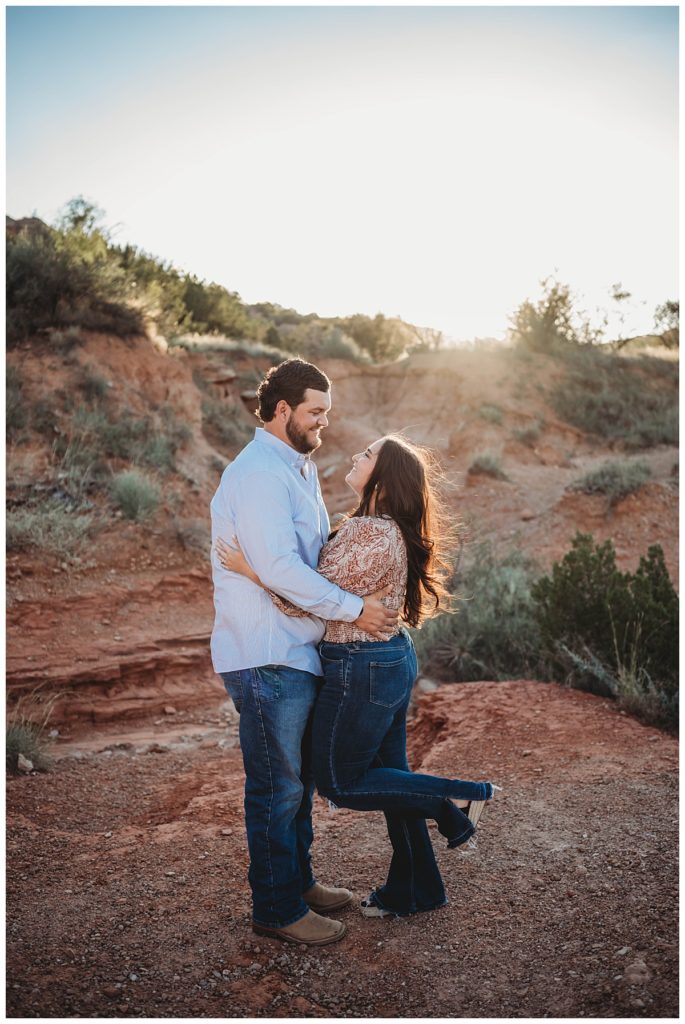 woman popping foot in west Texas canyon with fiance by Three Feather Photo Co
