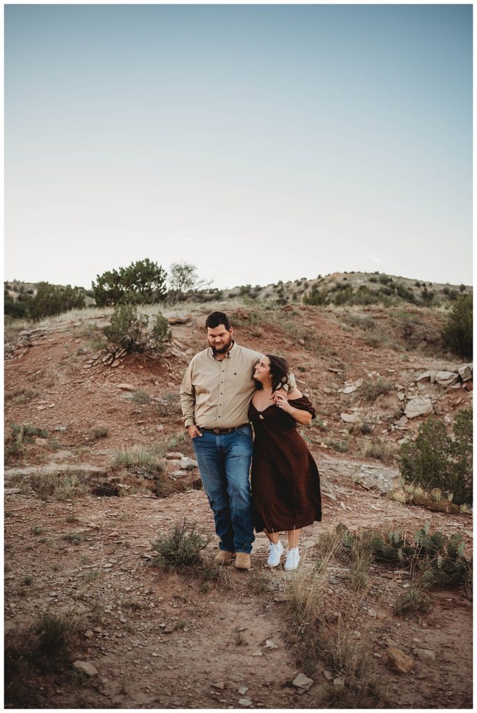 man and woman walking in nature for golden hour engagement session