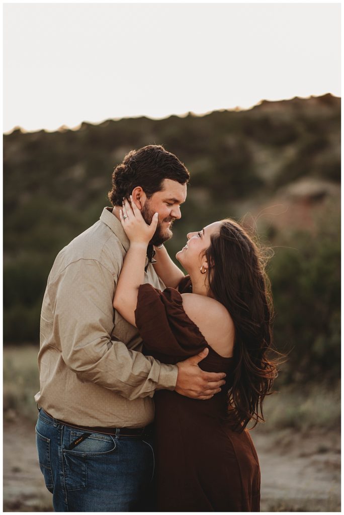 woman about to kiss as man at golden hour engagement session