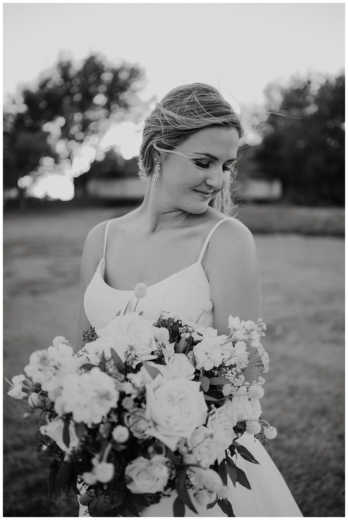 Bride holds bouquet and looks over shoulder by Amarillo portrait photographer